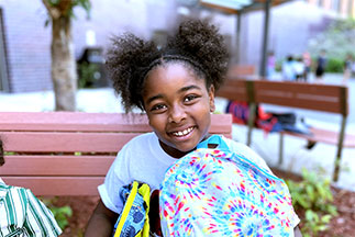 A little girl smiling on a park bench. Links to Closely Held Business Stock