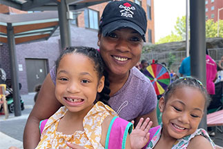 A mother and her daughters smiling. Links to What to Give A mother and her daughters smiling. Links to What to Give